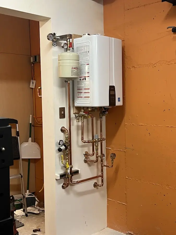Plumbing technician inspecting water heater connections in Tuscaloosa